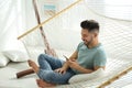 Young man using smartphone in hammock Royalty Free Stock Photo