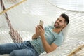 Young man using smartphone in hammock Royalty Free Stock Photo