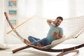 Young man using smartphone in hammock Royalty Free Stock Photo