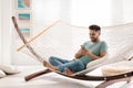 Young man using smartphone in hammock Royalty Free Stock Photo
