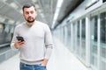 Young man using smartphone to check schedule on subway station Royalty Free Stock Photo