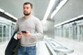 Young man using smartphone to check schedule on subway station Royalty Free Stock Photo