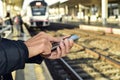 Young man using a smartphone in a train station Royalty Free Stock Photo