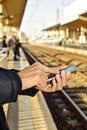 Young man using a smartphone in a train station Royalty Free Stock Photo