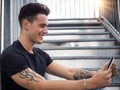 Young man using tablet PC sitting on metal stairs outside Royalty Free Stock Photo