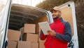 Young man using tablet to view information about the parcel. Delivering the package