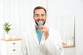 Young man using teeth whitening device Royalty Free Stock Photo