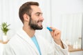 Young man using teeth whitening device Royalty Free Stock Photo