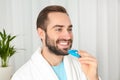 Young man using teeth whitening device Royalty Free Stock Photo