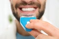Young man using teeth whitening device on light background Royalty Free Stock Photo