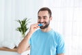 Young man using teeth whitening device Royalty Free Stock Photo