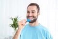 Young man using teeth whitening device Royalty Free Stock Photo