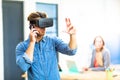 Young man using the virtual reality headset while talking on phone Royalty Free Stock Photo