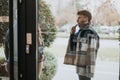 Young man vaping outside modern building through reflective glass window