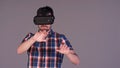 Young man in virtual reality glasses touching an imaginary screen