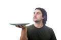 Young man waiter holding an empty dish plate in his hands isolated on white background. People has no food to eat after drought