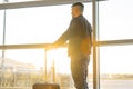 A young man waiting to board at the airport during sunset. Royalty Free Stock Photo