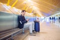 Young man waiting and using mobile phone at the airport Royalty Free Stock Photo