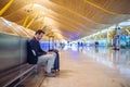 Young man waiting and using mobile phone at the airport Royalty Free Stock Photo