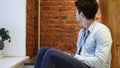 Young Man Waiting and Watching Time on Watch, Sitting on Stairs