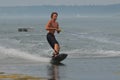 Young Man Wakeboarding in Casco Bay with a Dinghy in the Background Royalty Free Stock Photo