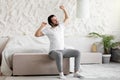 Young man waking up in bed and stretching his arms Royalty Free Stock Photo