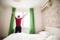 Young man waking up in bed and stretching his arms in whte morning Royalty Free Stock Photo