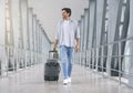 Young man walking in airport walkway with luggage Royalty Free Stock Photo
