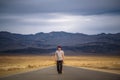 Young man walking alone through an empty street in the desert of Death Valley