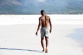 Young man walking barefoot on beach Royalty Free Stock Photo