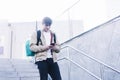 Young man walking down stairs with backpack while using mobile outdoors Royalty Free Stock Photo