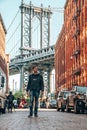 Young man walking down the Washington street, in Brooklyn with a Manhattan