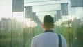 A Young Man Walking in a Glass Corridor Royalty Free Stock Photo