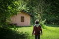 Young man walking in the green towards a pink cottage Royalty Free Stock Photo