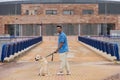 Young man walking with his brown Labrador retrieve dog. The photo is taken from behind. And in the background a building. Concept