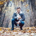 Young man walking his dog having a stroll in the autumn park Royalty Free Stock Photo