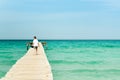 Young man walking on a long wood pier