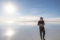 Young man walking and looking away with perfect blue sky reflection in Salar de Uyuni - Uyuni Salt Flats in Bolivia Royalty Free Stock Photo