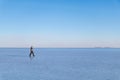 Young man walking and looking away with perfect blue sky reflection in Salar de Uyuni - Uyuni Salt Flats in Bolivia Royalty Free Stock Photo