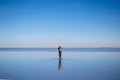 Young man walking and looking away with perfect blue sky reflection in Salar de Uyuni - Uyuni Salt Flats in Bolivia Royalty Free Stock Photo