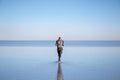 Young man walking and looking away with perfect blue sky reflection in Salar de Uyuni - Uyuni Salt Flats in Bolivia Royalty Free Stock Photo