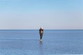 Young man walking and looking away with perfect blue sky reflection in Salar de Uyuni - Uyuni Salt Flats in Bolivia Royalty Free Stock Photo