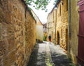 Young man walking in a narrow alley in the city center of the medieval village of Gourdon in Lot, France Royalty Free Stock Photo