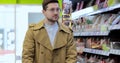 Young man walking with shopping cart in supermarket. Stylish man pushing shopping cart with products. Big store with Royalty Free Stock Photo