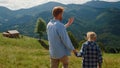 Young man walking son green hill. Father enjoying family weekend with boy. Royalty Free Stock Photo