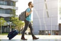 Young man walking with suitcase and bag Royalty Free Stock Photo