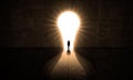 Young Man walking thought a Shiny light Bulb Door. Getting out From darkness to lightness and Illumination Royalty Free Stock Photo