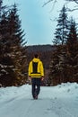 Young man walking on winter czech forest path in yellow jacket Royalty Free Stock Photo