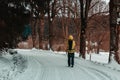 Young man walking in winter czech landscape on forest path in yellow jacket Royalty Free Stock Photo