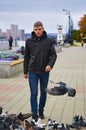 A young man walks along the embankment of the river with pigeons in the foreground. Lighthouse and street lights in blur Royalty Free Stock Photo